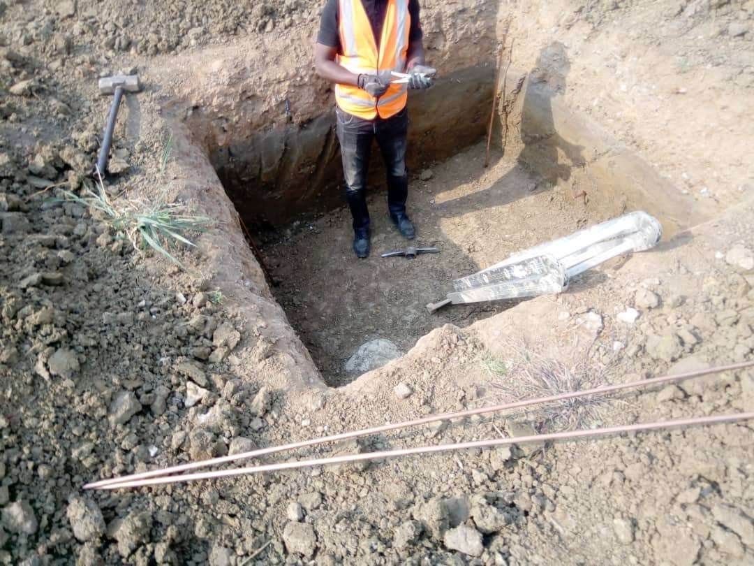 Excavated earth pit with copper conductor laid beside it
