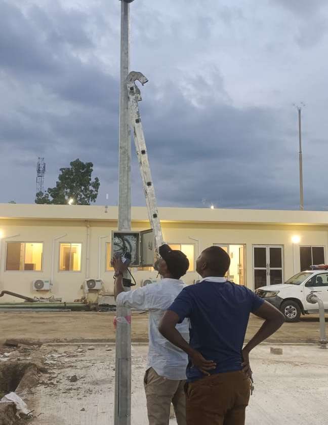 Two engineers checking a mounted lighting pole